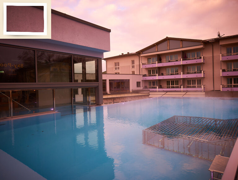 Ein großer Außenpool im Zentrum des modernen Wellnesshotels Holzapfels in Bad Füssing bei Dämmerung.