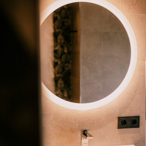 Elegantes Badezimmer mit einem Waschbecken und glänzendem Spiegel im Einzelzimmer Standart des Thermenhotels Holzapfel in Bayern.