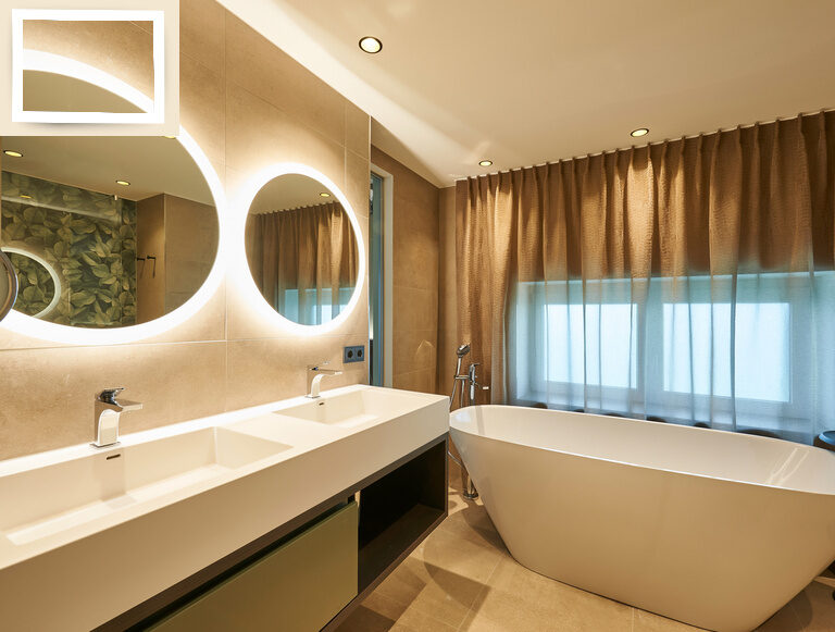 Luxuriöse Wellness-Atmosphäre mit Badewanne und Spiegel im Badezimmer des Einzelzimmer Standart des 4-Sterne-Hotel Holzapfel im Rottal.