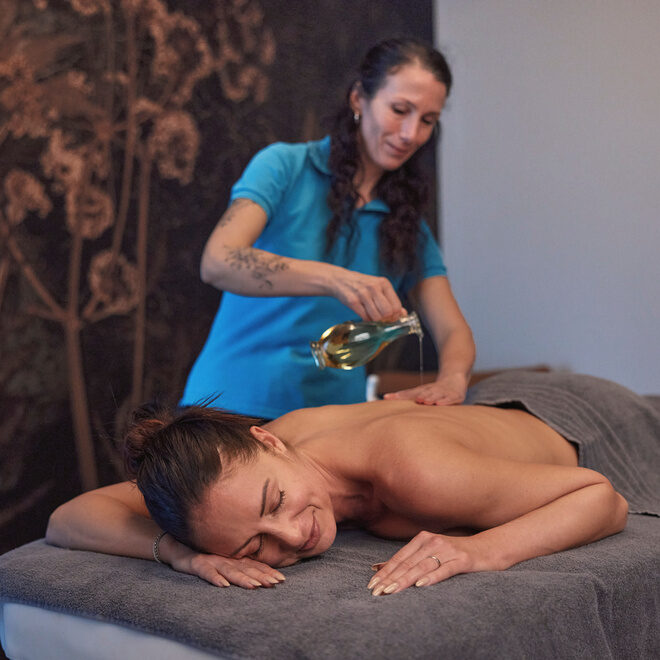 Sanfte entspannende Ölmassage einer Frau in dem stilvollen Spa des Wellnesshotels Holzapfel im Rottal.