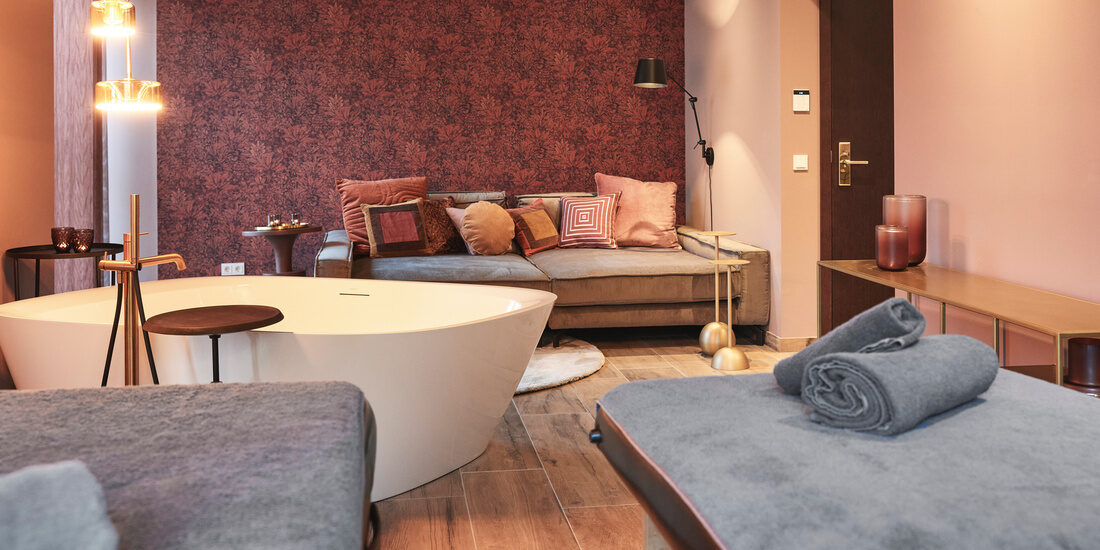 Gemütlich eingerichtetes Beauty- und Kosmetikzimmer mit bequemen Sofa und Massagetischen im Thermenhotel Holzapfel in Bayern lädt zum Verweilen ein.