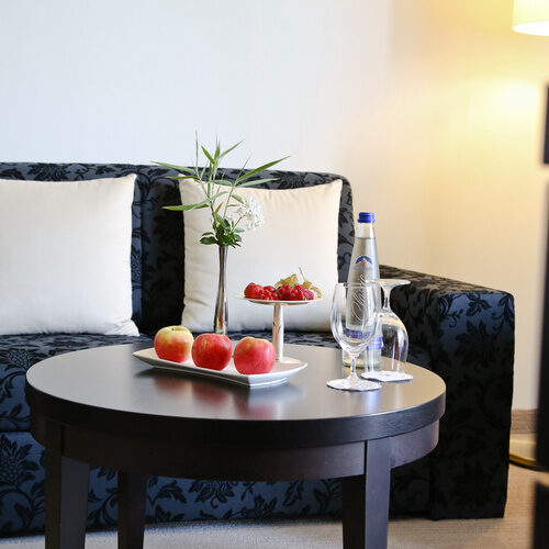 Ein schickes, elegant blumig gemustertes Sofa im gemütlichen Wohnzimmer des Doppelzimmer Deluxe Süd im Thermenhotel Holzapfel bei Passau.