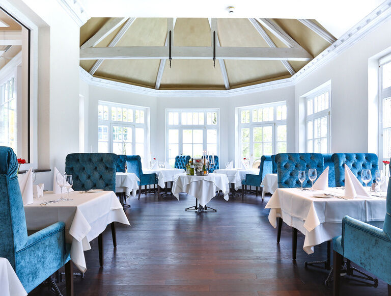 Das elegante Restaurant Glockenturm mit blauen Stühlen im Fitnesshotel Holzapfel.