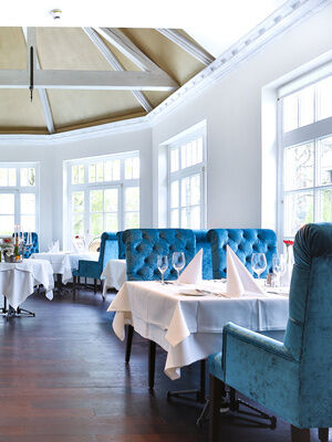 Das elegante Restaurant Glockenturm mit blauen Stühlen im Fitnesshotel Holzapfel.