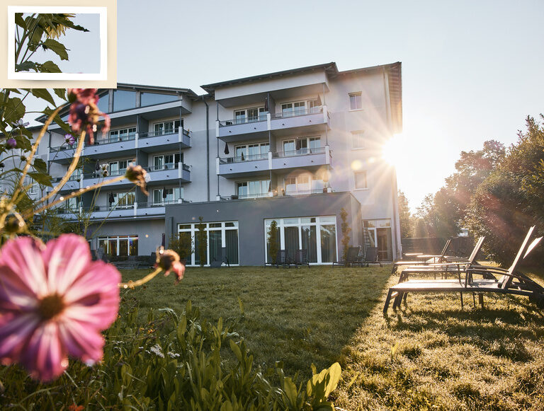 Das einladende Hotel Holzapfel umrahmt von lebendigen Blumen und Wiesen.