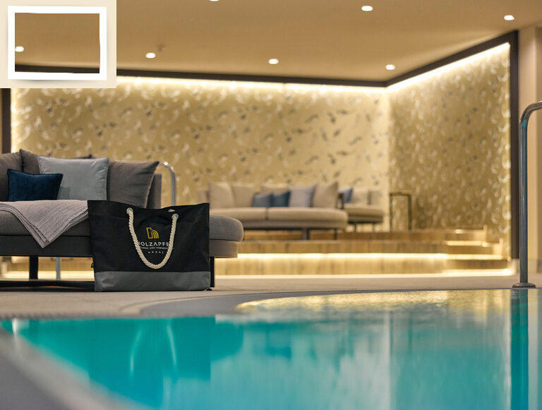Eine gemütliche Couch neben dem Thermalwasser Pool im Innenbereich des Hotel Holzapfel in Niederbayern.