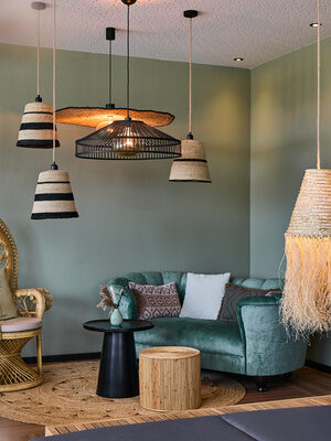 Ein gemütlicher Raum mit einem Sessel neben dem Sofa.