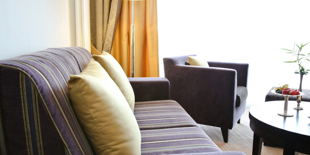 Zwei gemütliche Sofas umgeben einen stilvollen Couchtisch im Doppelzimmer Deluxe Süd des Gesundheithotels Holzapfel in Bad Füssing.