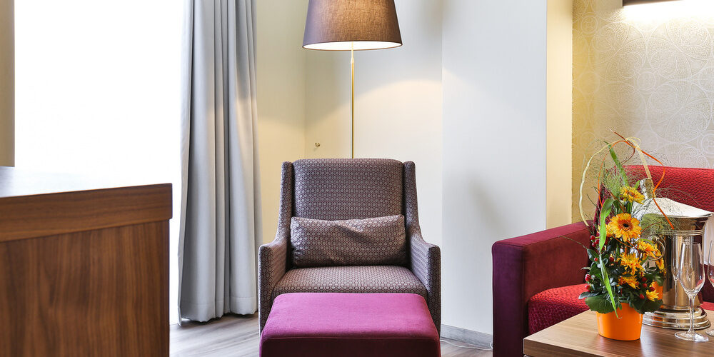 gemütlicher Sitzbereich im Doppelzimmer Comfort des Thermenhotels Holzapfel, ausgestattet mit zwei bequemen Sesseln und einem dekorierten Tisch.