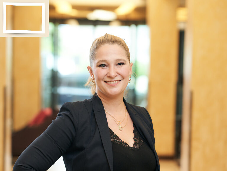Die Geschäftsleitung Michaela Holzapfel mit modischem Blazer im Korridor des 4-Sterne-Thermenhotels Holzapfel im Rottal..