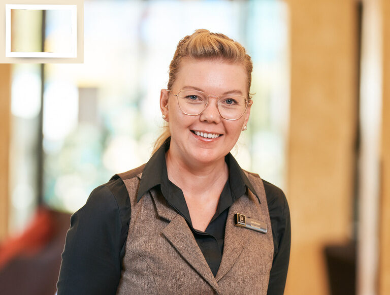 Die Hausdame Julia Bauer lächelnd in einer Weste im Wellnesshotel Holzapfel Bad Füssing..