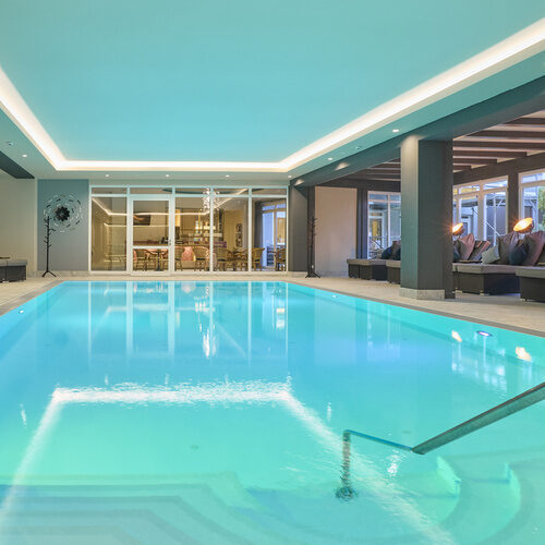 Ein geräumiges Hallenbad mit entspannendem Ambiente im Thermenhotel Holzapfel in Bad Füssing.