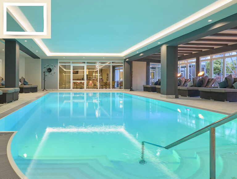 Ein geräumiges Hallenbad mit entspannendem Ambiente im Thermenhotel Holzapfel in Bad Füssing.