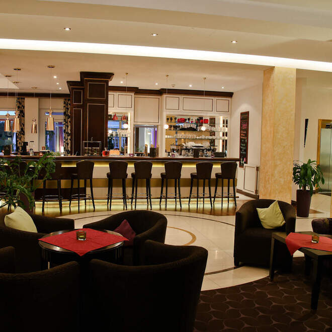 Einladende Hotellobby mit gemütlichen Sofas und Tischen im Thermenhotel Holzapfel im Rottal.