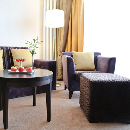 Ein gemütliches Set aus Sesseln und Tisch in der Lounge Ecke des Doppelzimmer Deluxe Ost im Wellnesshotel Holzapfel in Bayern.