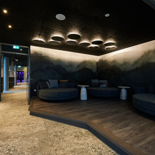 Eine elegante Lounge mit zwei Sofas und stilvoller Beleuchtung im Spabereich des Wellnesshotels Holzapfel, Bad Füssing.