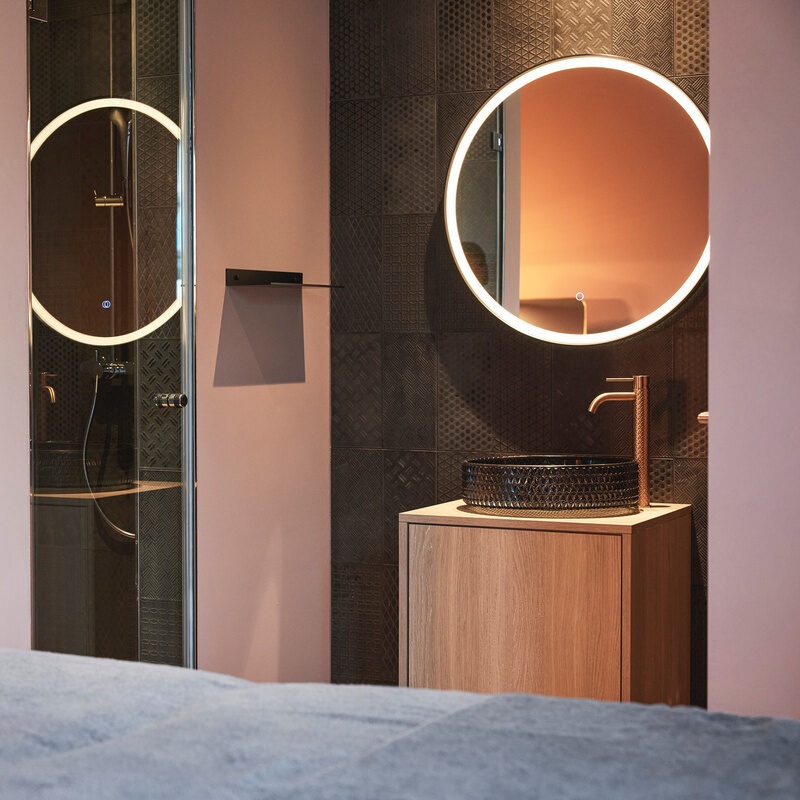Modern gestaltetes Kosmetikzimmer im Wellnesshotel Holzapfel mit komfortablem Massagetisch und glänzendem Spiegel.