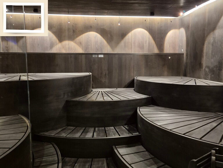 Im modernen Saunabereich des Wellnesshotels Holzapfel bei Passau schaffen Bänke und Beleuchtung Gemütlichkeit.