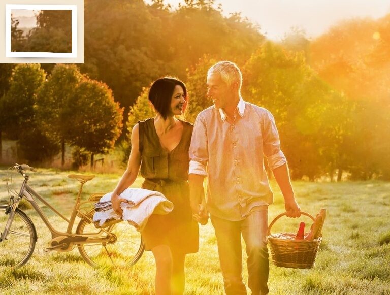 Ein Mann und eine Frau erleben einen romantischen Moment auf dem Weg zu einem Picknick bei Abendstimmung.
