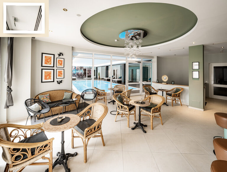 Komfortable Sitzmöglichkeiten mit Tischen direkt an der Innenpoolbar des Thermenhotels Holzapfel für eine Pause nach dem schwimmen.