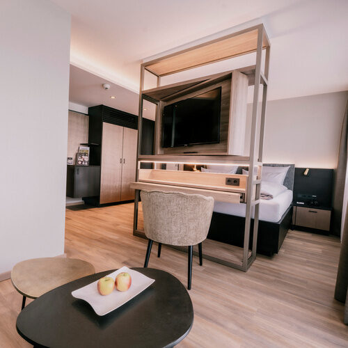 Elegantes Schlafzimmer im Doppelzimmer Comfort mit großem Fernseher im Wellnesshotel Holzapfel in Bad Füssing.