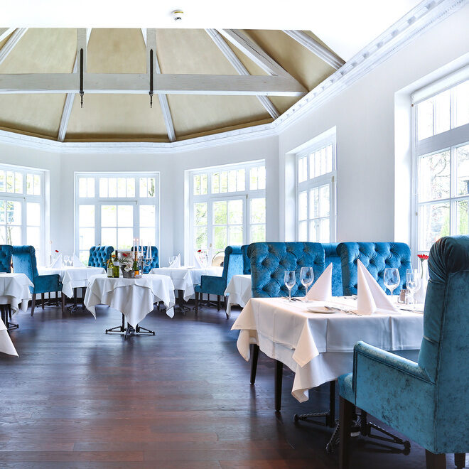 Das elegante Restaurant Glockenturm mit blauen Stühlen im Fitnesshotel Holzapfel.