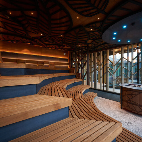 Holzverkleidete Saunab&auml;nke mit durchdachter Beleuchtung in der Sauna des Wellnesshotels Holzapfel.