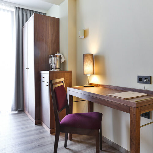 Geschmackvolle minimalistische Arbeitsecke mit Schreibtisch und Stuhl im Einzelzimmer Comfort des Thermenhotels Holzapfel.