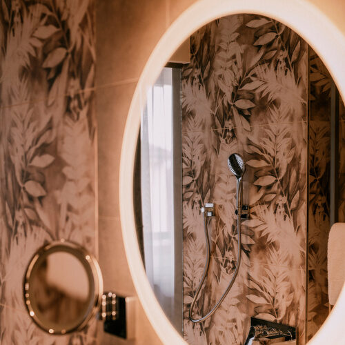 Harmonisches Licht des Spiegels beleuchtet das Badezimmer der Suite Goldrenette im Wellnesshotel Holzapfel bei Passau.