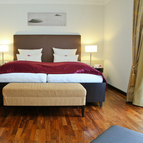 Gemütliches großes Bett in der Suite Elstar des Wellnesshotel Holzapfel, Bad Füssing.