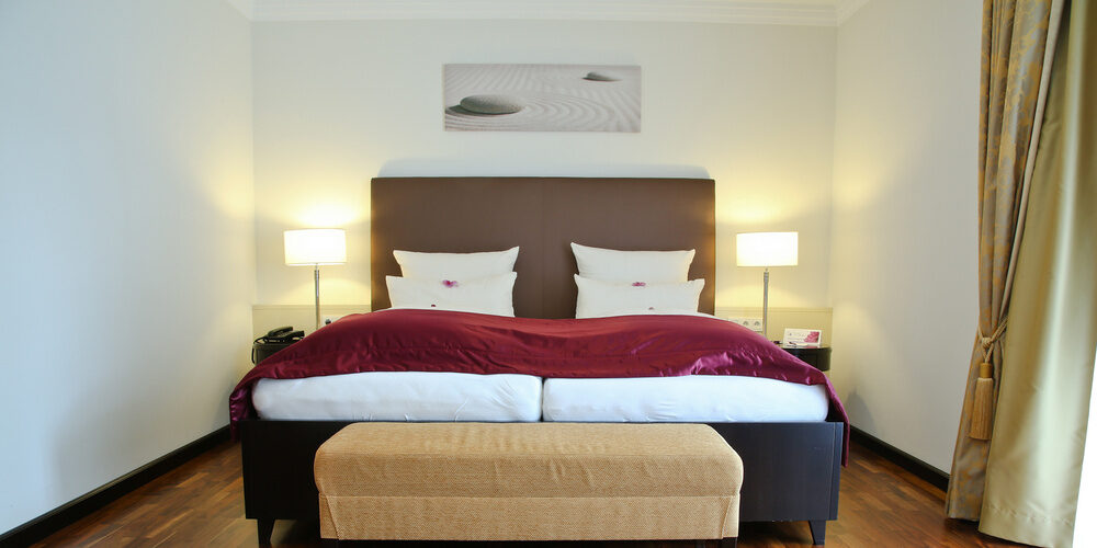 Gemütliches großes Bett in der Suite Elstar des Wellnesshotel Holzapfel, Bad Füssing.