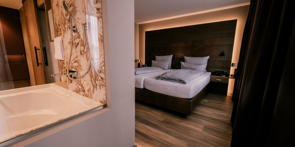 Stilvoll eingerichtete Suite Goldrenette mit großer Badewanne und Bett im Wellnesshotel Holzapfel bei Passau.