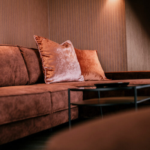 Ein braunes Sofa im Wohnbereich der Suite Goldrenette - Hotel Holzapfel in Bayern..